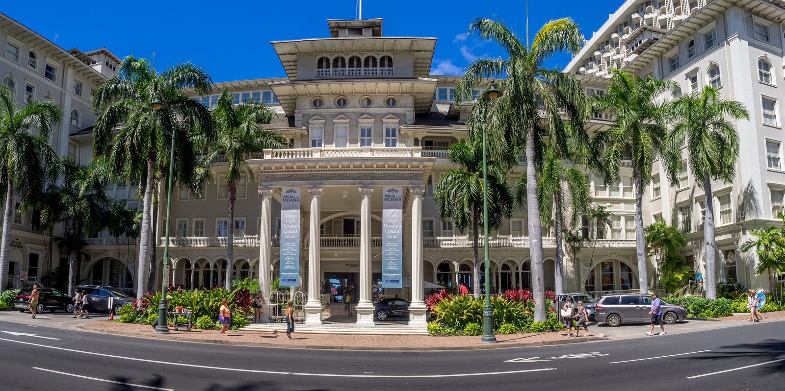 Colonnaded facade of the historic Moana hotel framed by palms on Kalakaua Avenue in Waikiki